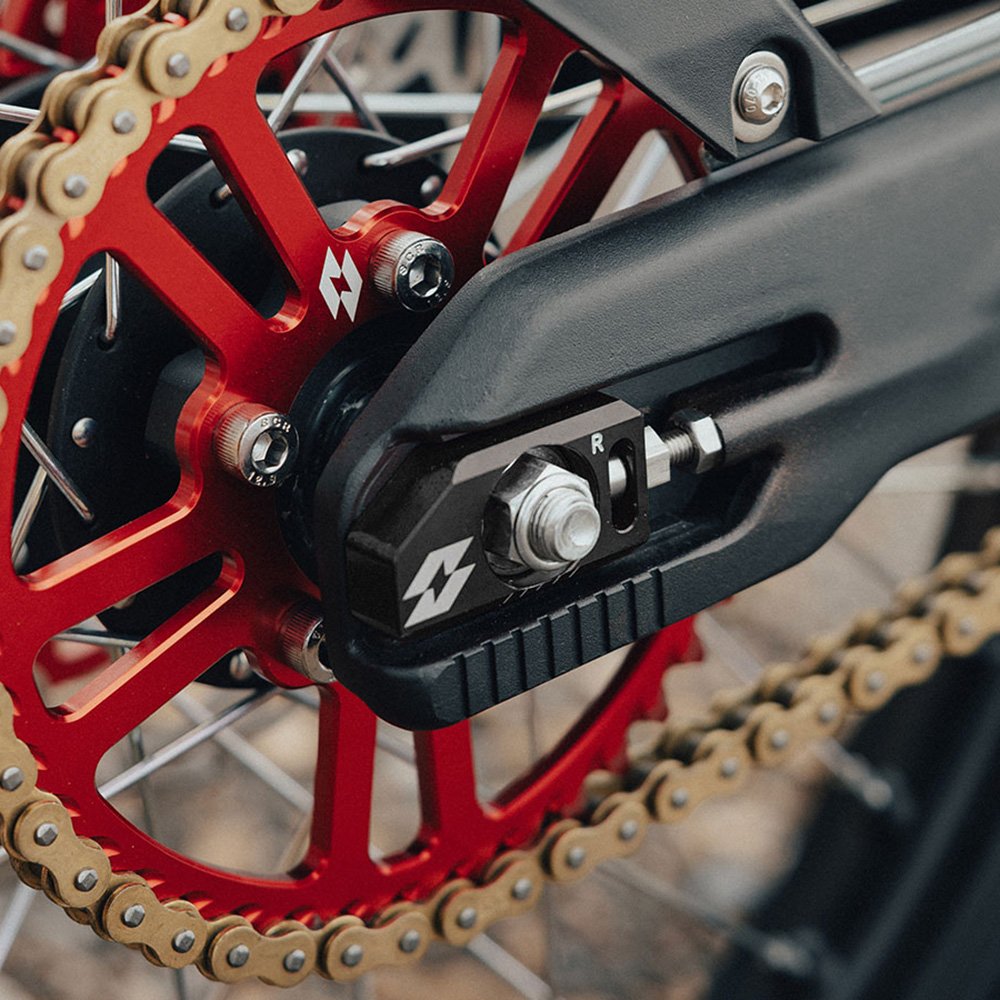 Black chain adjuster fitted to a swingarm