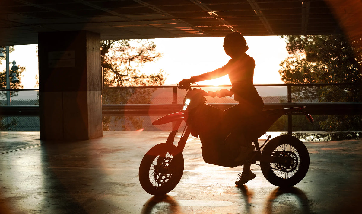 Rider on a Stark VARG SM in a parking structure at sunset, official Stark photograph