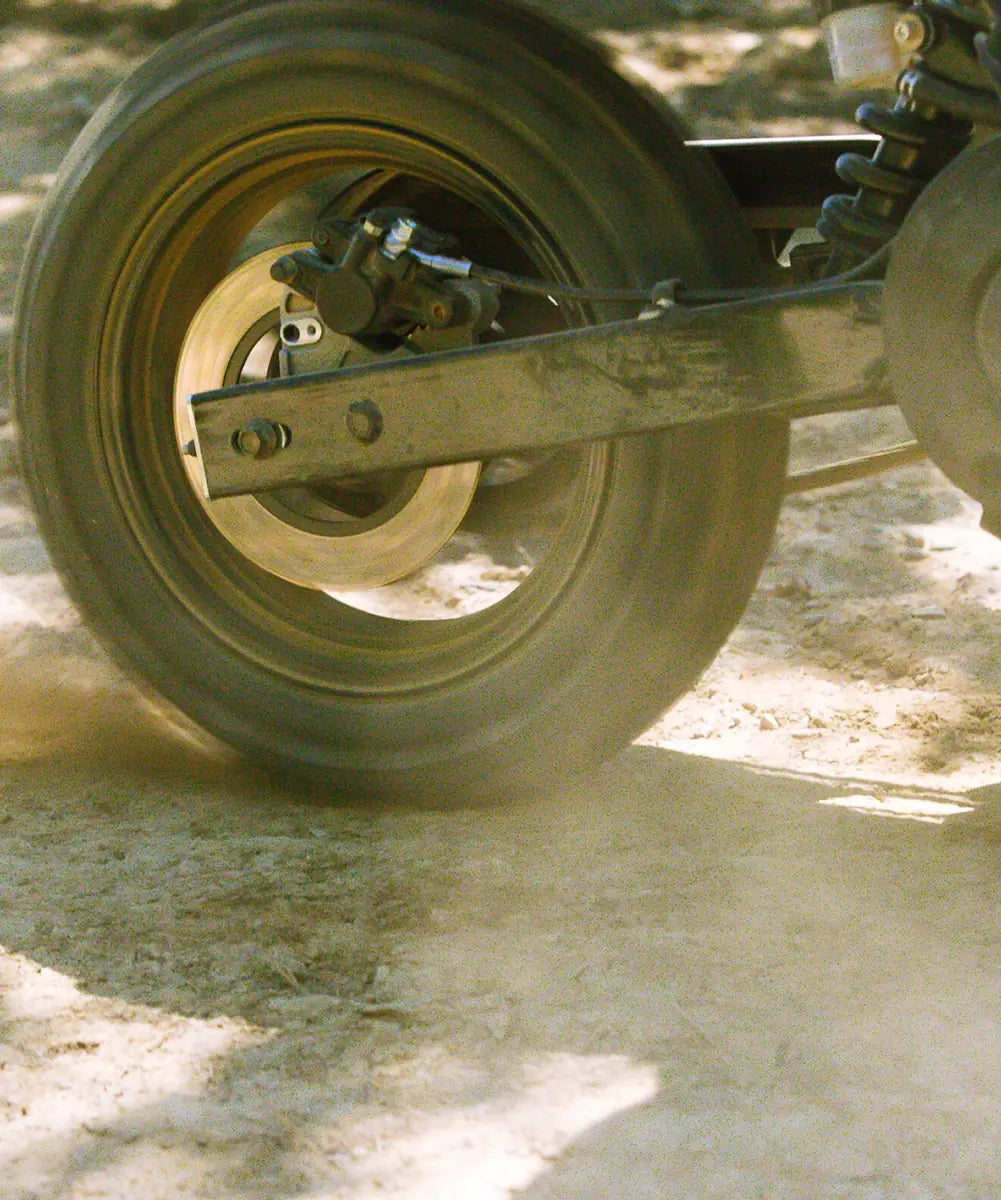 Close-up of the LiveWire S4 Honcho Trail rear wheel and swingarm on a dirt surface