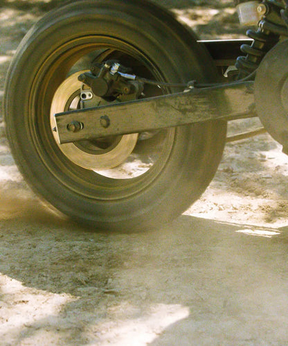 Close-up of the LiveWire S4 Honcho Trail rear wheel and swingarm on a dirt surface